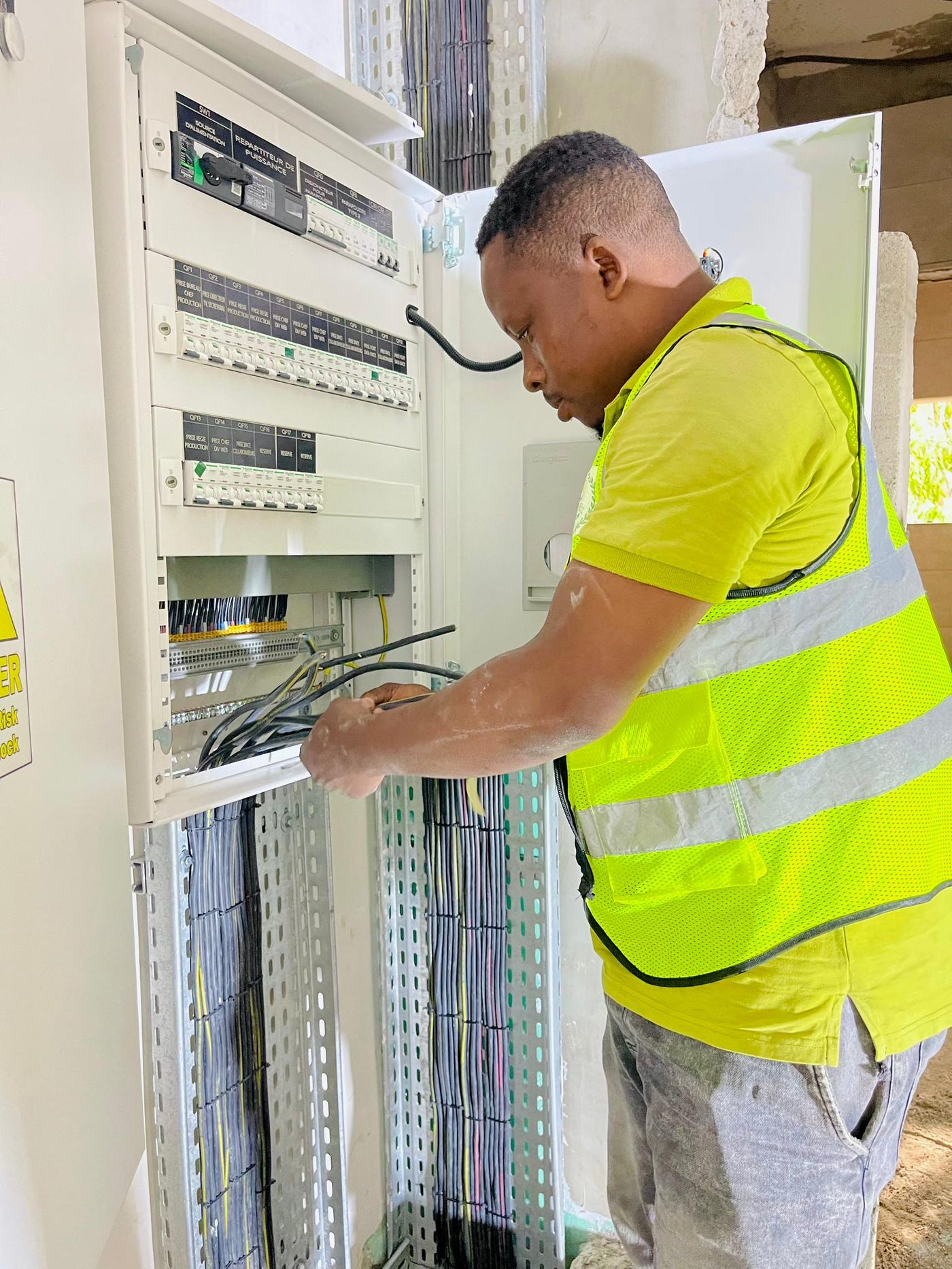Technicien JT Service raccordant un répartiteur de puissance sur un chantier