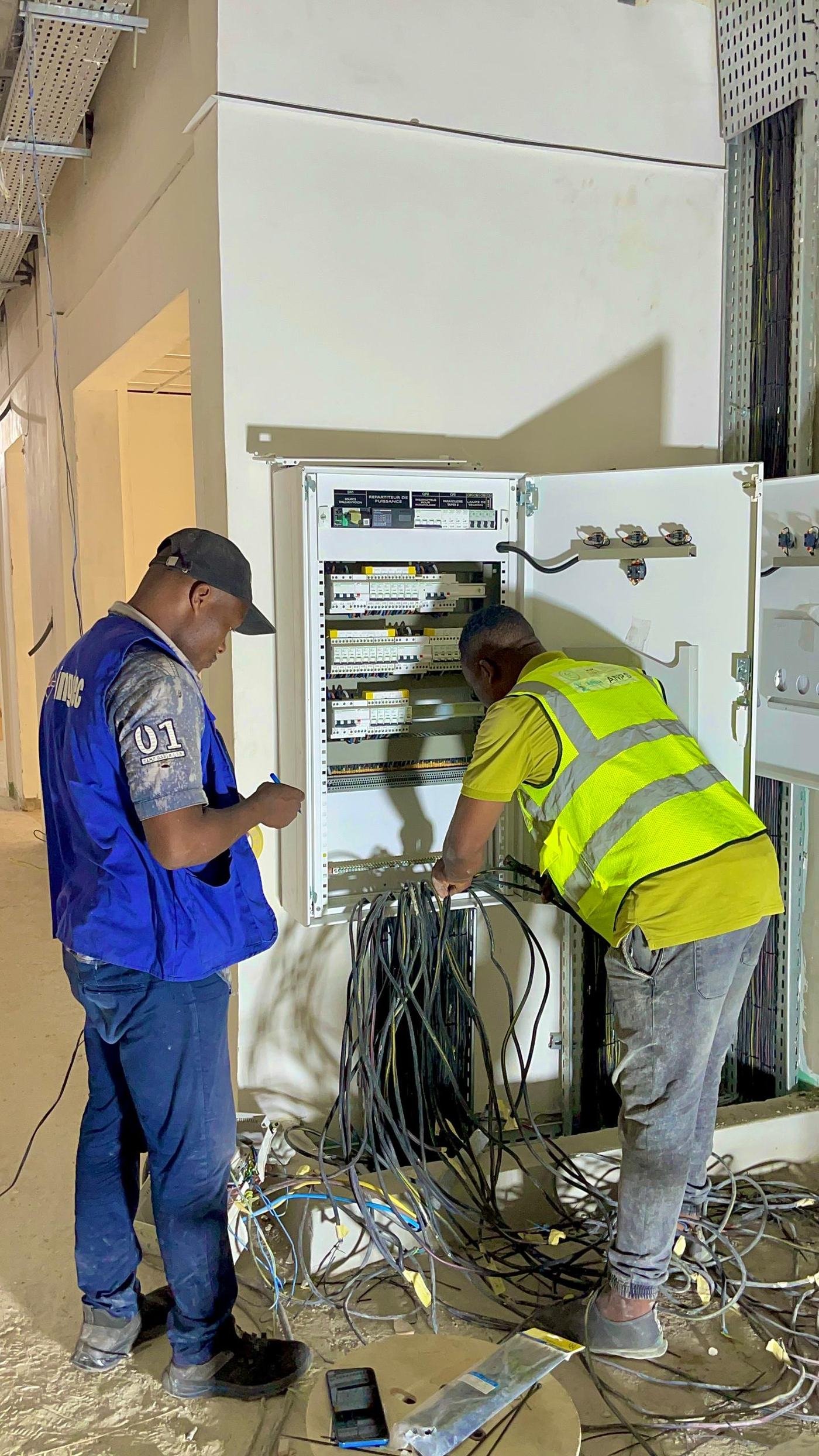Techniciens JT Service vérifiant un tableau de distribution sur un site en travaux